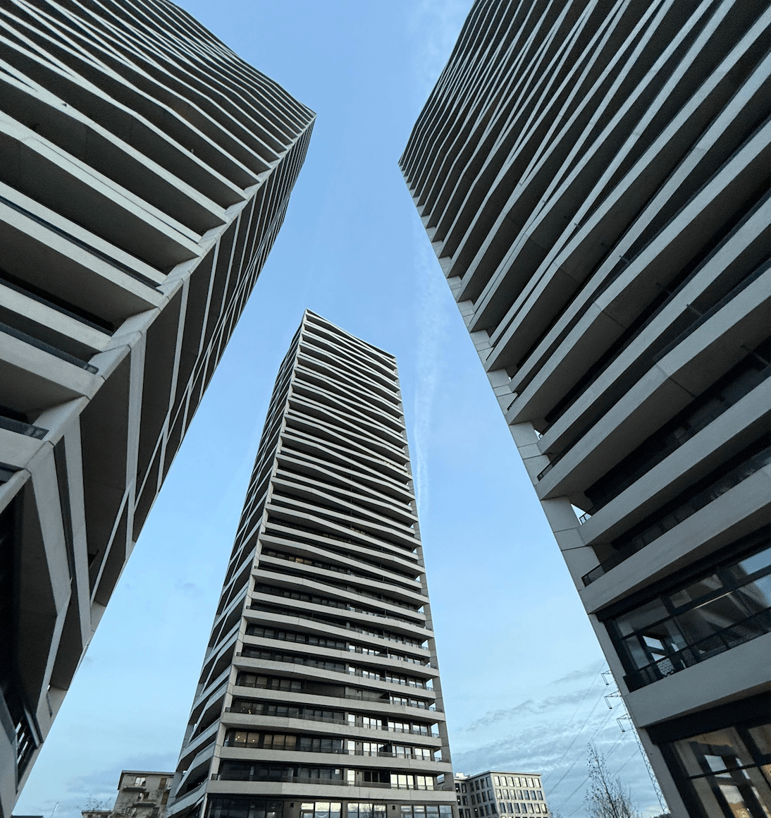Contemporary apartment buildings in Zurich with striking geometric design viewed from street level.