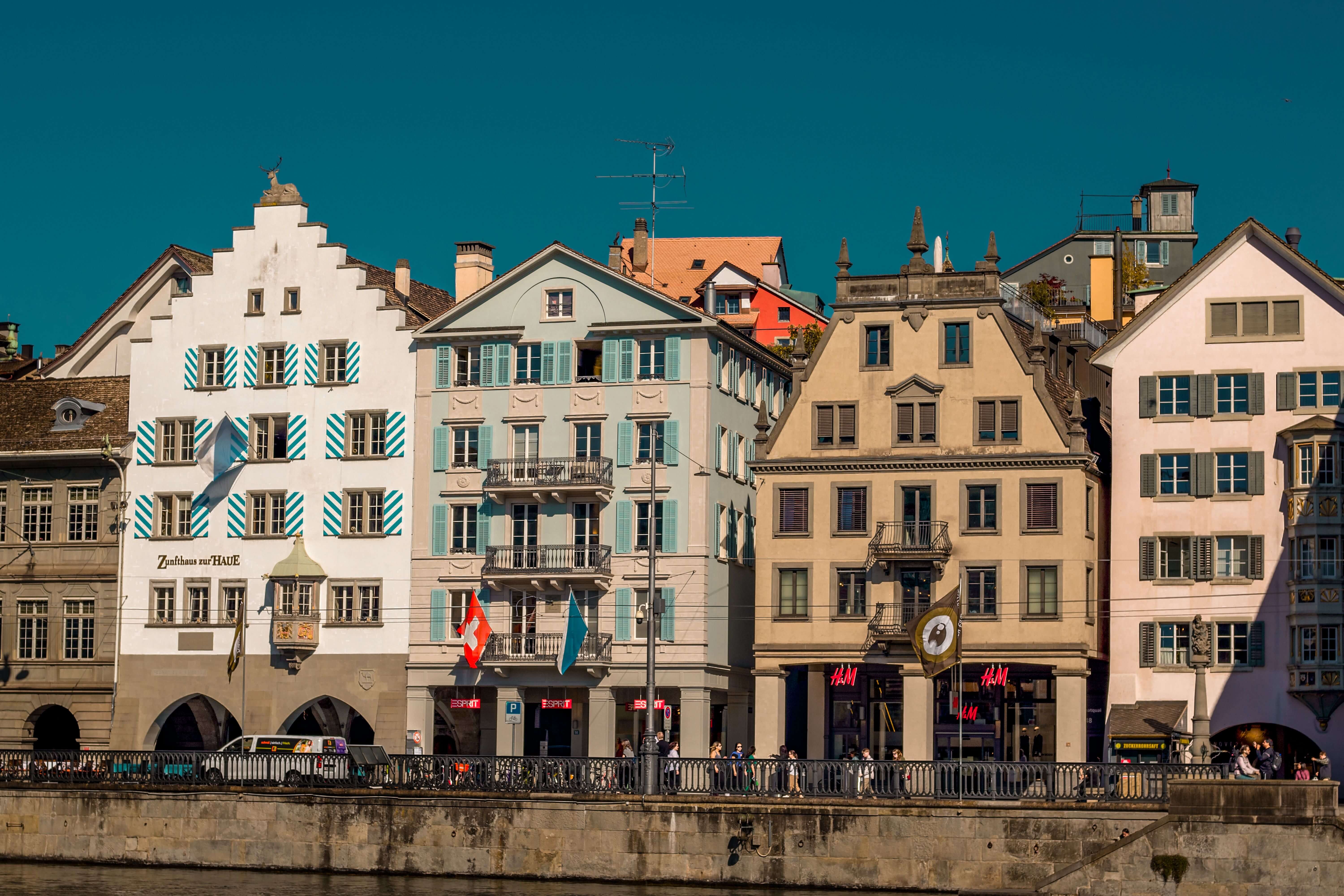 Historic buildings lining the Limmat River in Zurich's Old Town on a clear, sunny day